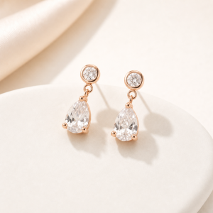 Clear quartz crystal earrings on warm white studio surface