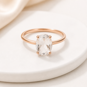 Clear quartz crystal ring on warm white studio surface